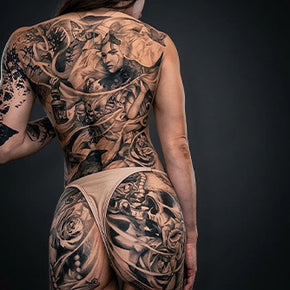 Tattooed person with detailed designs covering back and arm.