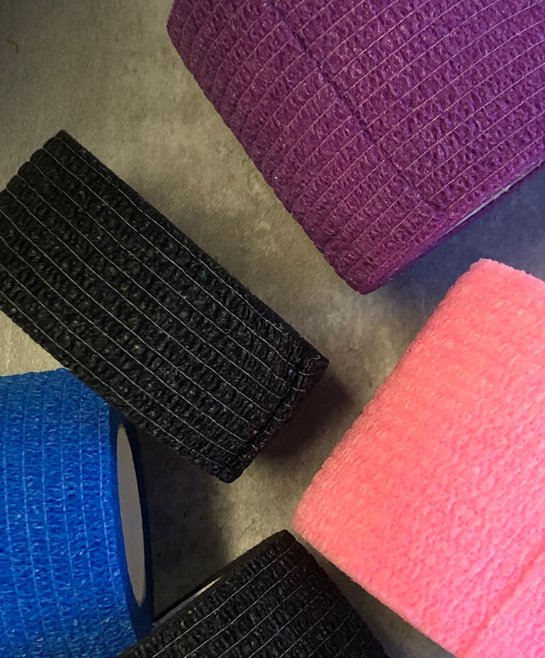 Rolls of textured tape in black, blue, purple, and pink.