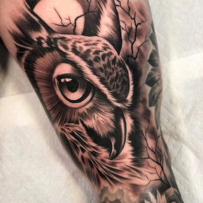 Owl tattoo featuring detailed shading and piercing eyes.
