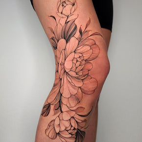 Floral tattoo design on a person's thigh and knee.