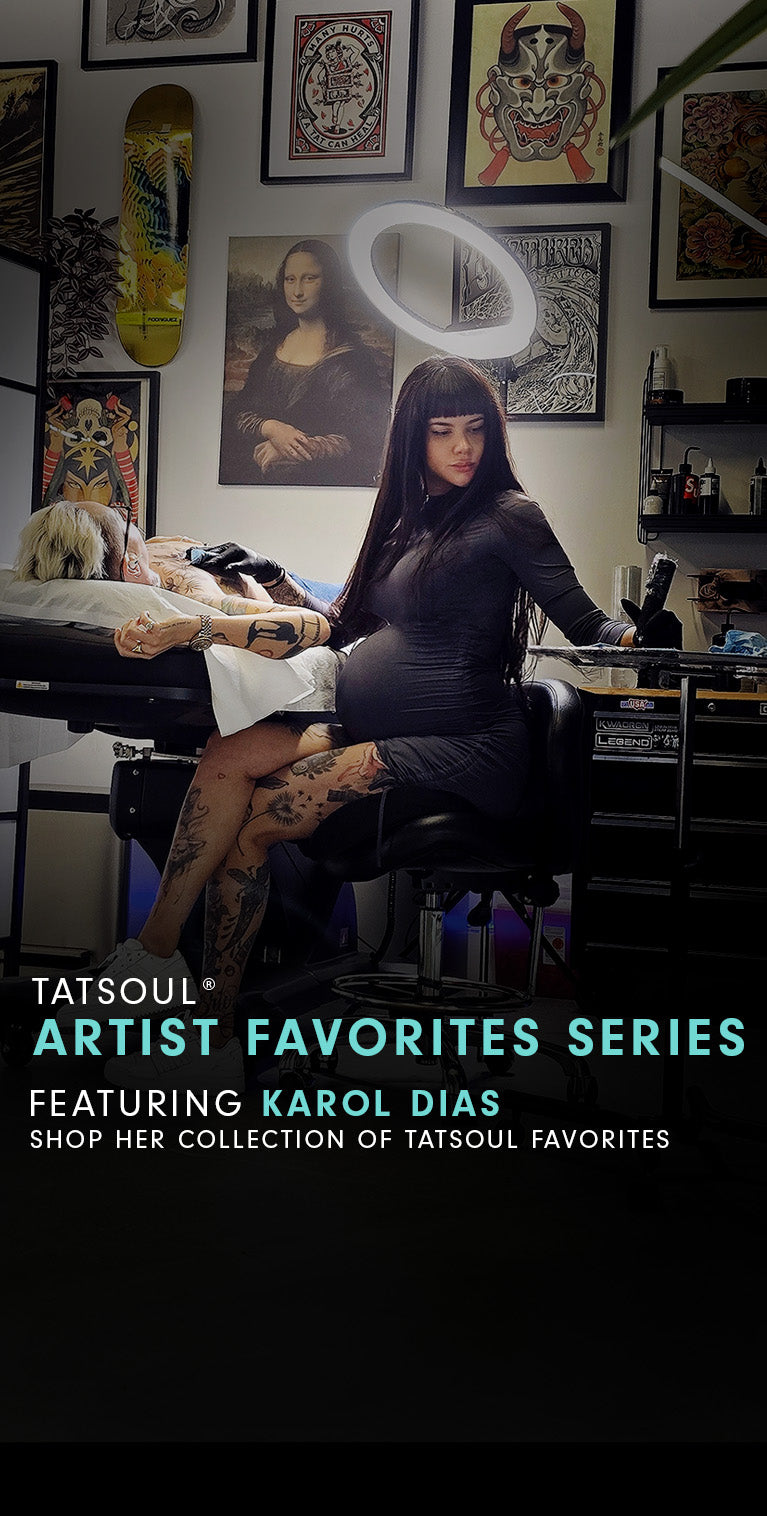 A tattoo artist working on a client in a studio, surrounded by wall art.