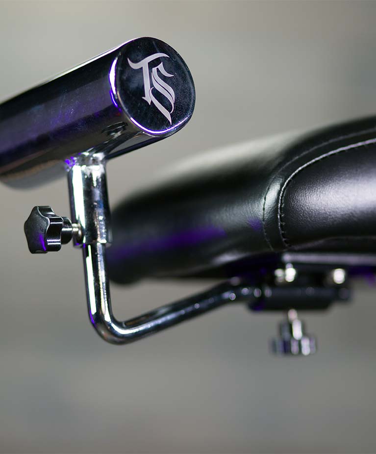 Chrome lever with a monogram logo on a black leather seat.