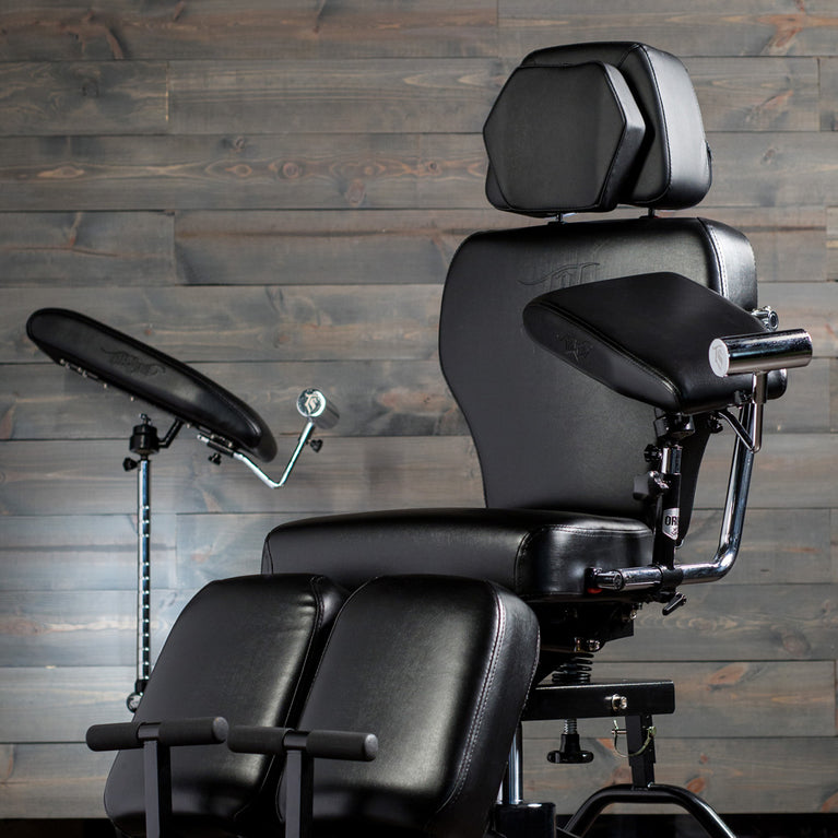 Tattoo chair with adjustable arm and headrests.