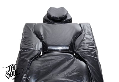 570 Tattoo Client Chair Protective Cover on a black chair. Oros Tattoo Client Chair Cover made of Protective Plastic, available at TATSoul.